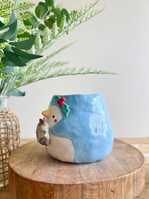 Festive penguin pot with grey cat friend