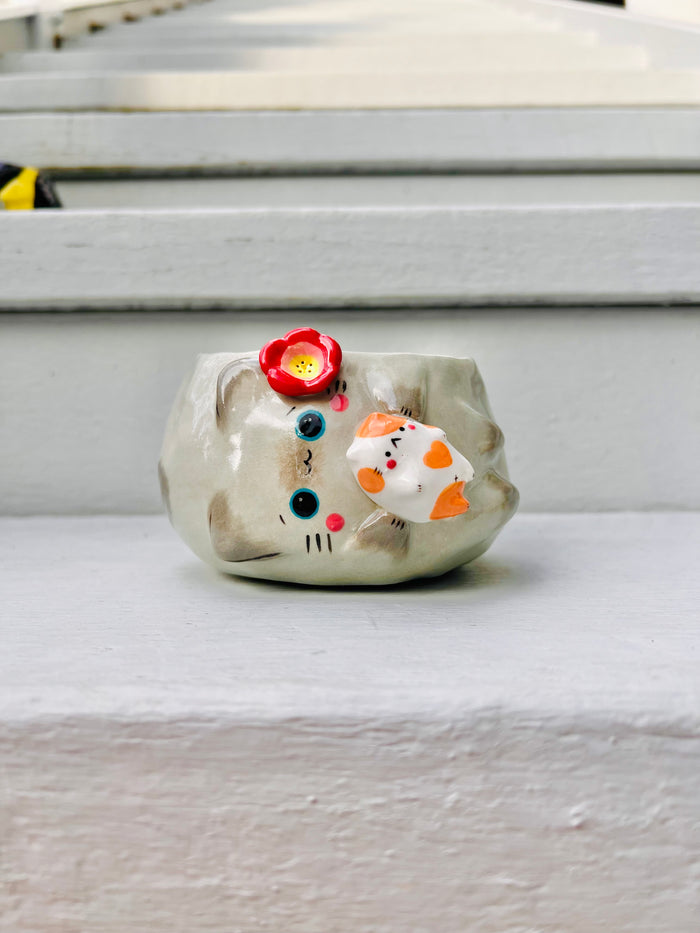 Sideways grey cat pot with ginger cat friend