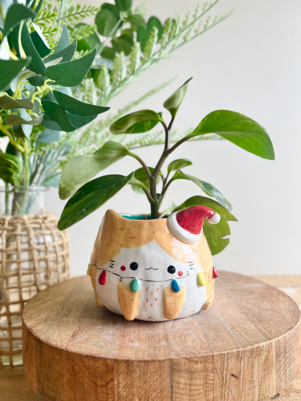 Festive ginger cat pot adorned with Christmas lights