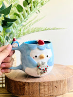 Festive Penguin mug with baby penguin and cat friend