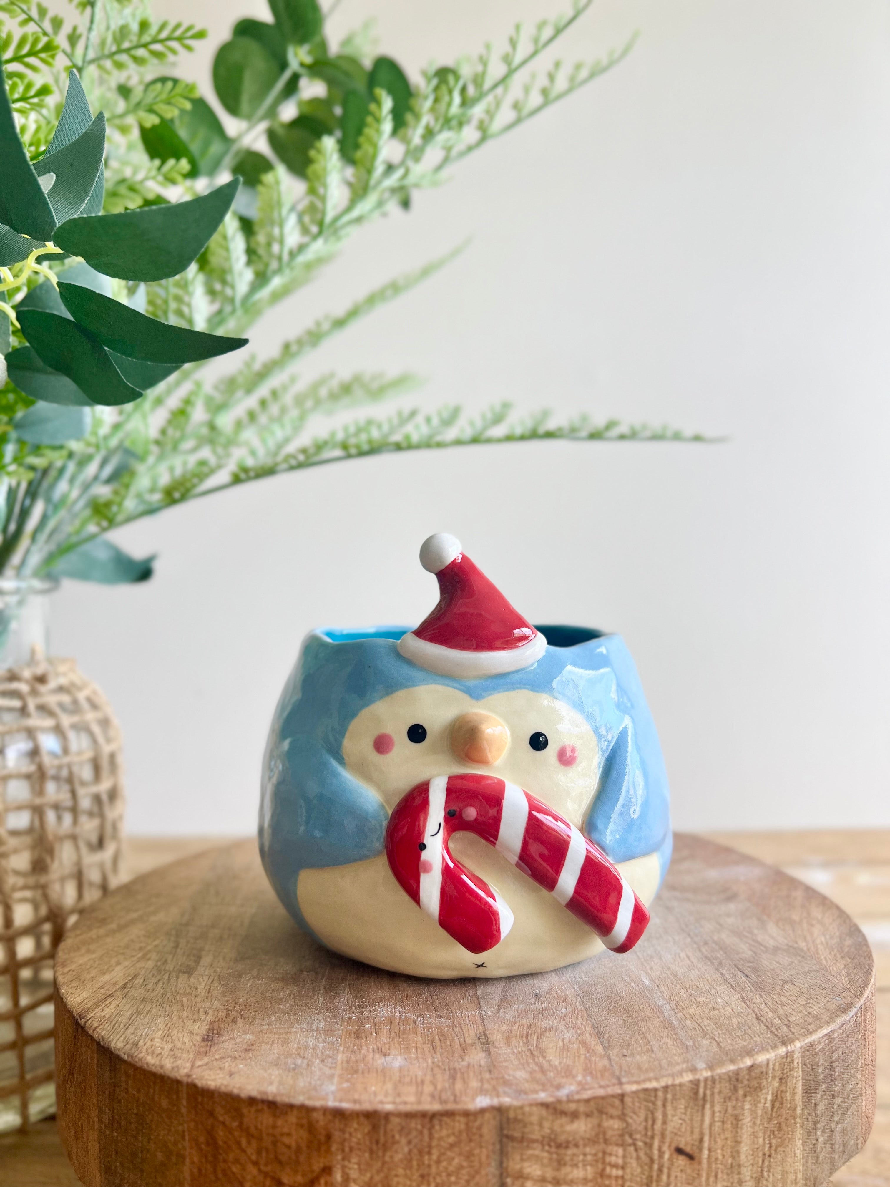 Festive penguin pot with giant candy cane friend