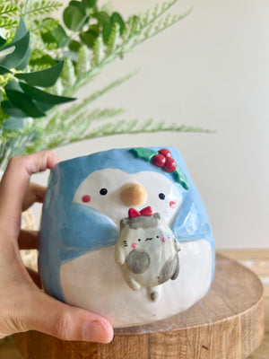 Festive penguin pot with grey cat friend