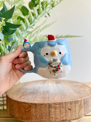 Festive Penguin mug with baby penguin and cat friend