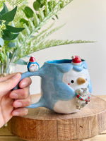 Festive Penguin mug with baby penguin and cat friend