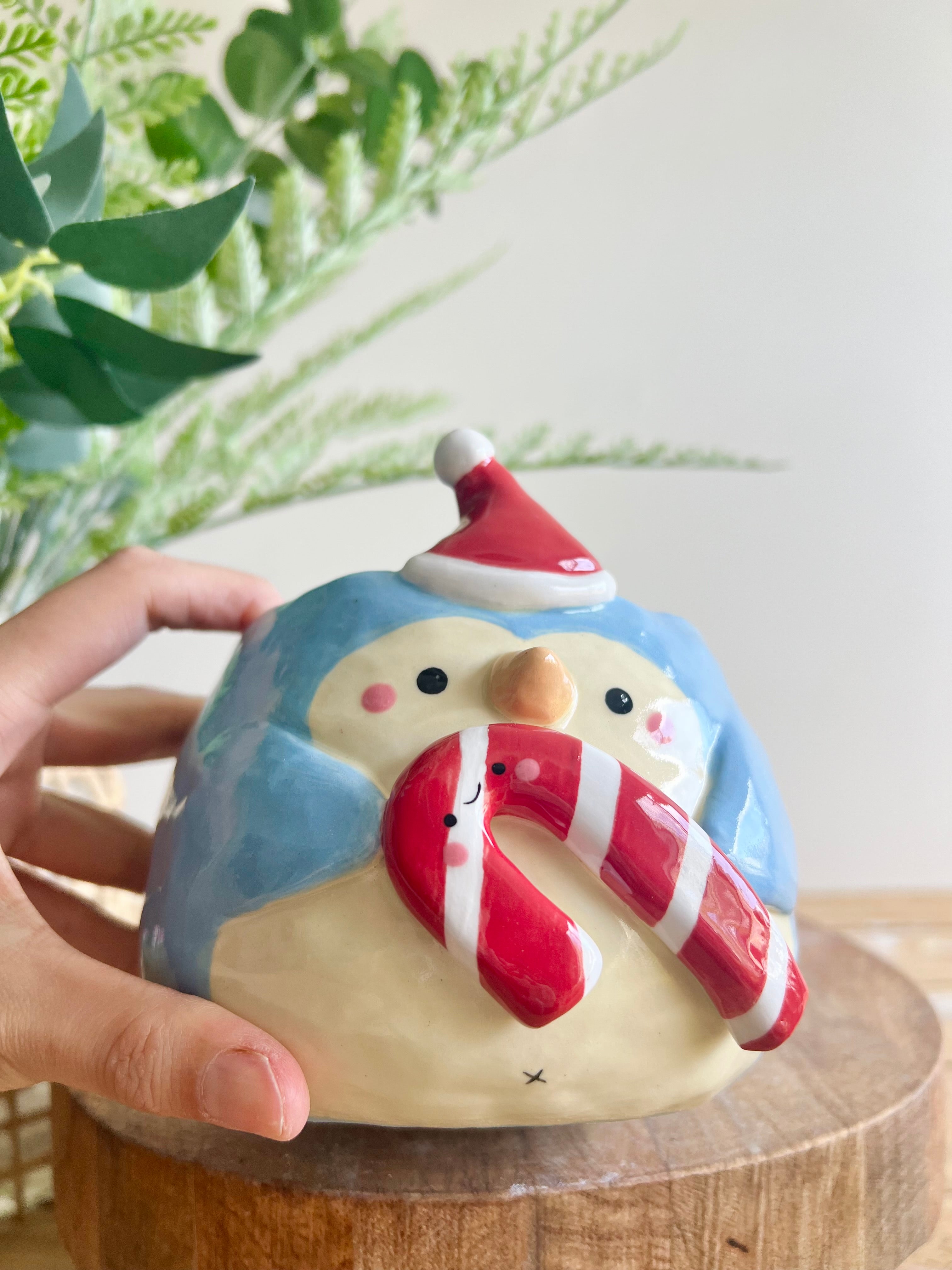 Festive penguin pot with giant candy cane friend