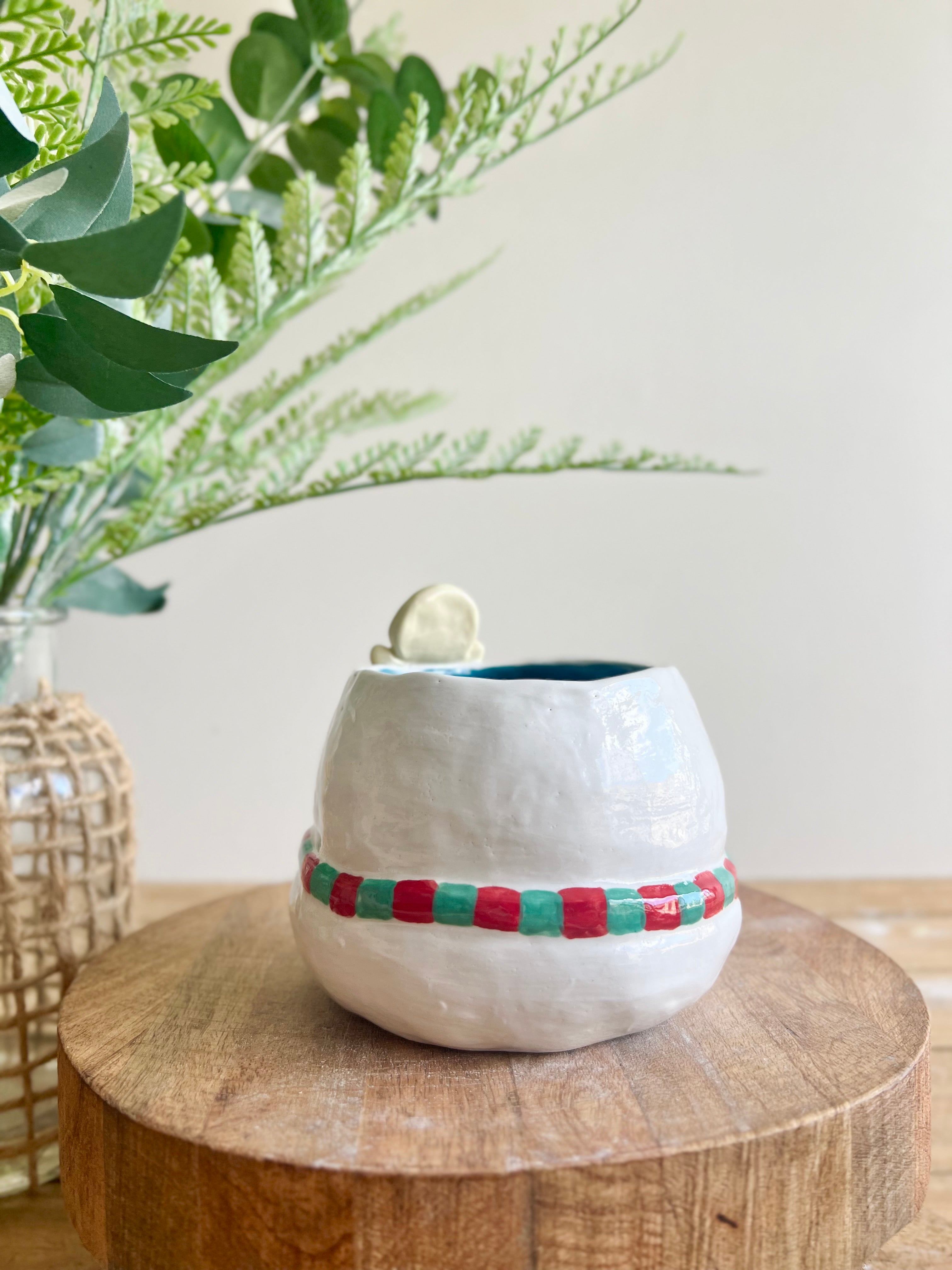 Festive snowman pot with gingerbread friend just chillin’ on its head