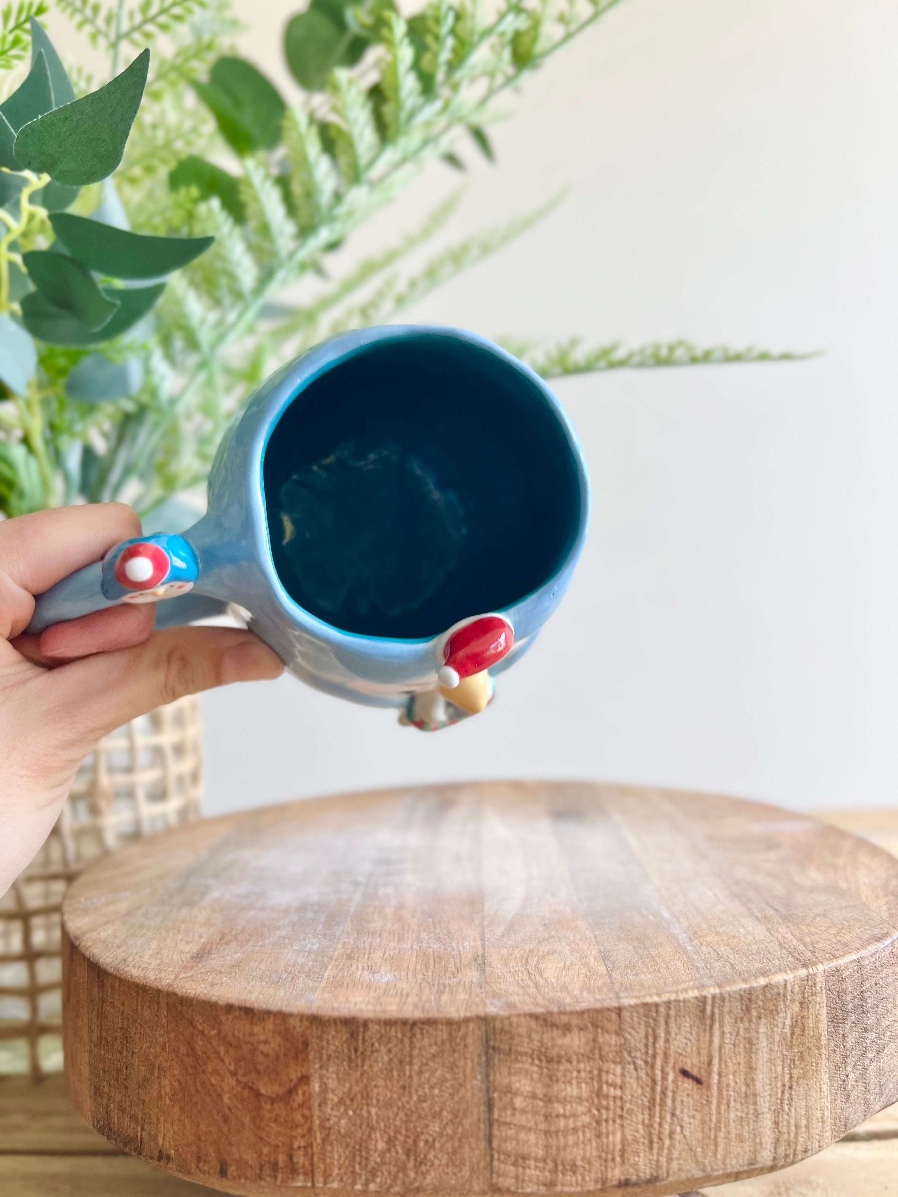 Festive Penguin mug with baby penguin and cat friend