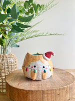 Festive ginger cat pot adorned with Christmas lights