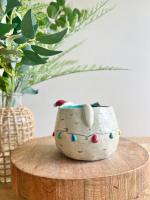 Festive grey cat pot adorned with Christmas lights