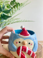 Festive penguin pot with giant candy cane friend