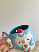 Festive Penguin mug with baby penguin and cat friend