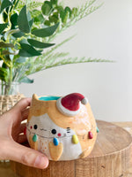 Festive ginger cat pot adorned with Christmas lights