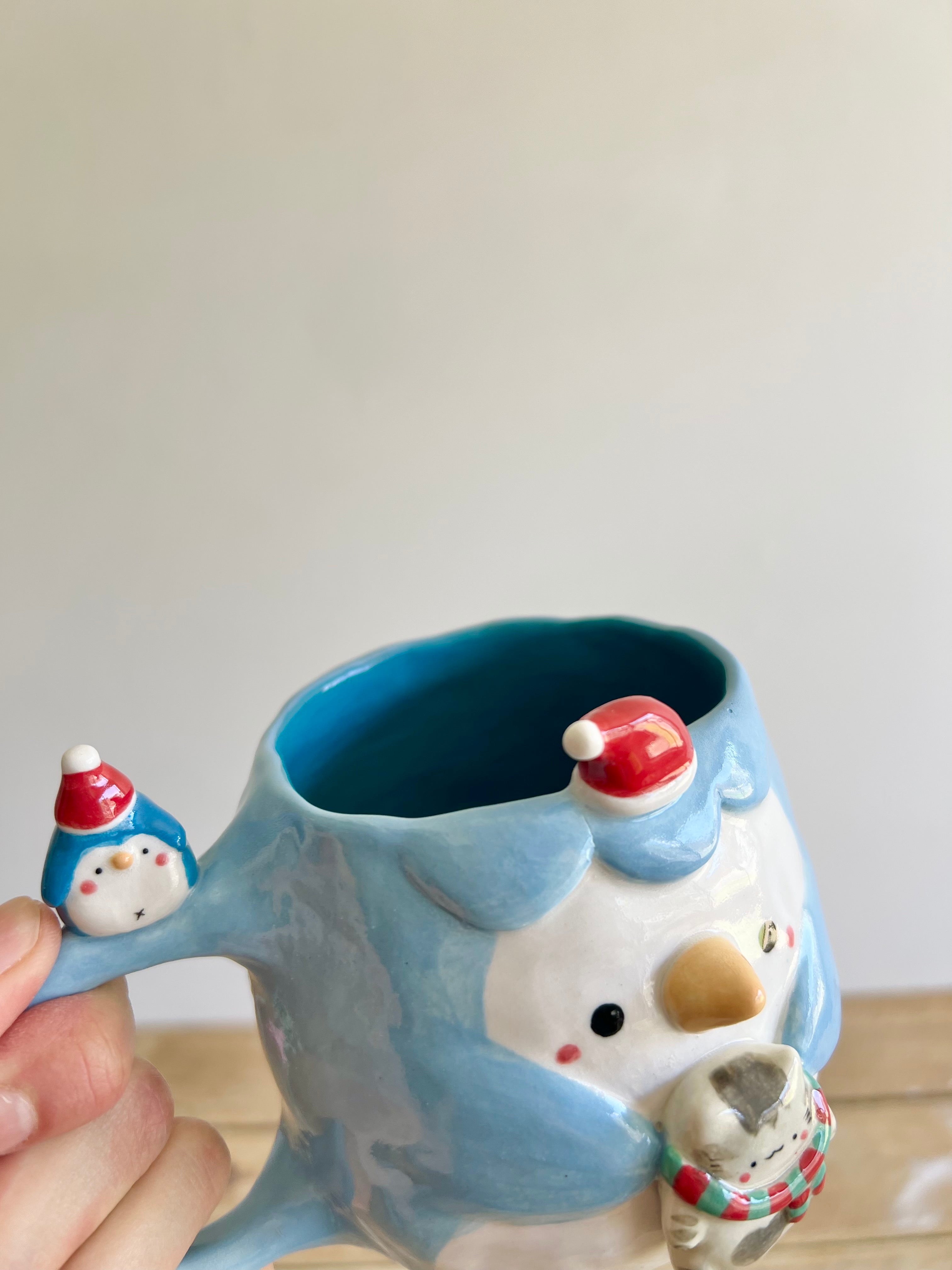 Festive Penguin mug with baby penguin and cat friend