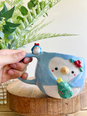 Festive Penguin mug with penguin baby and Christmas tree friend