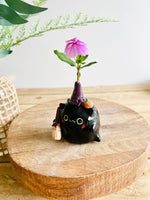 Black cat witch with broomstick and pumpkin friend bud vase