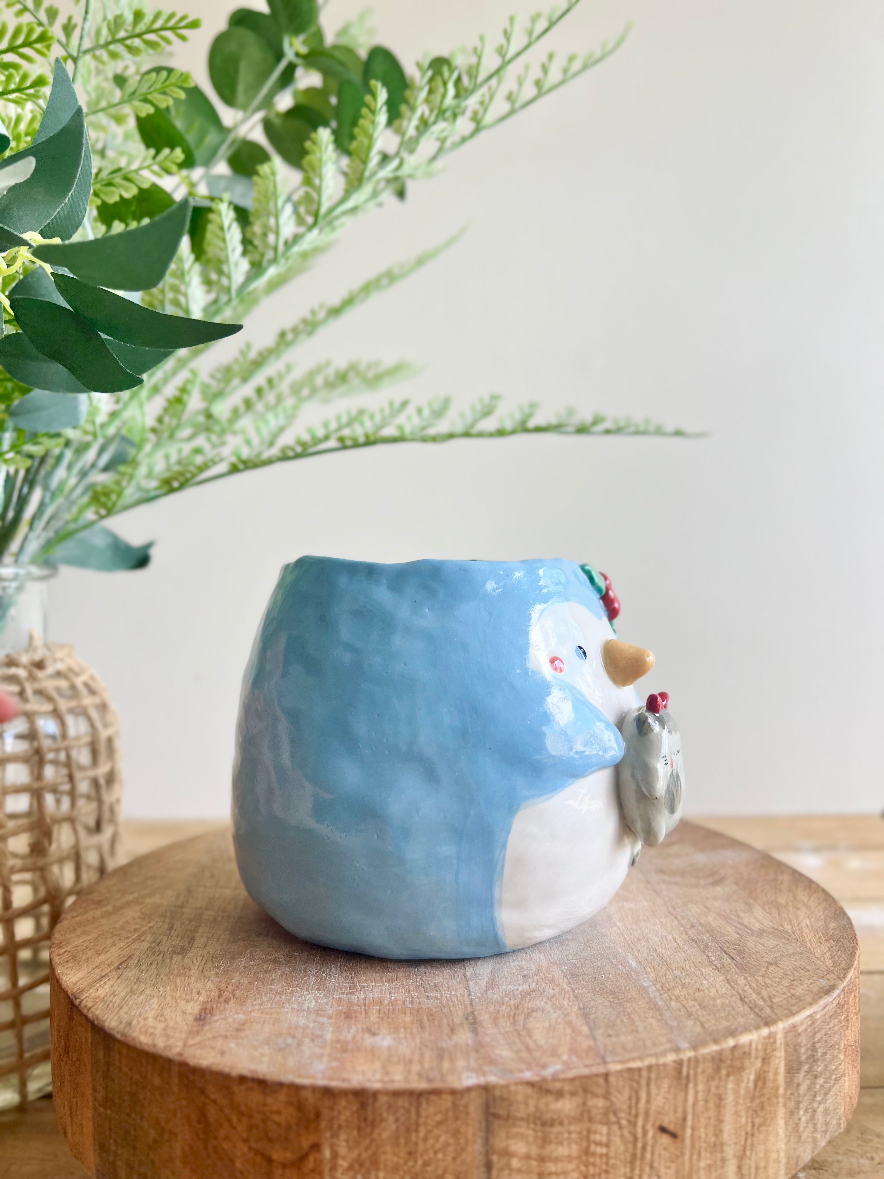 Festive penguin pot with grey cat friend