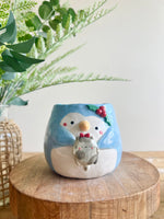 Festive penguin pot with grey cat friend