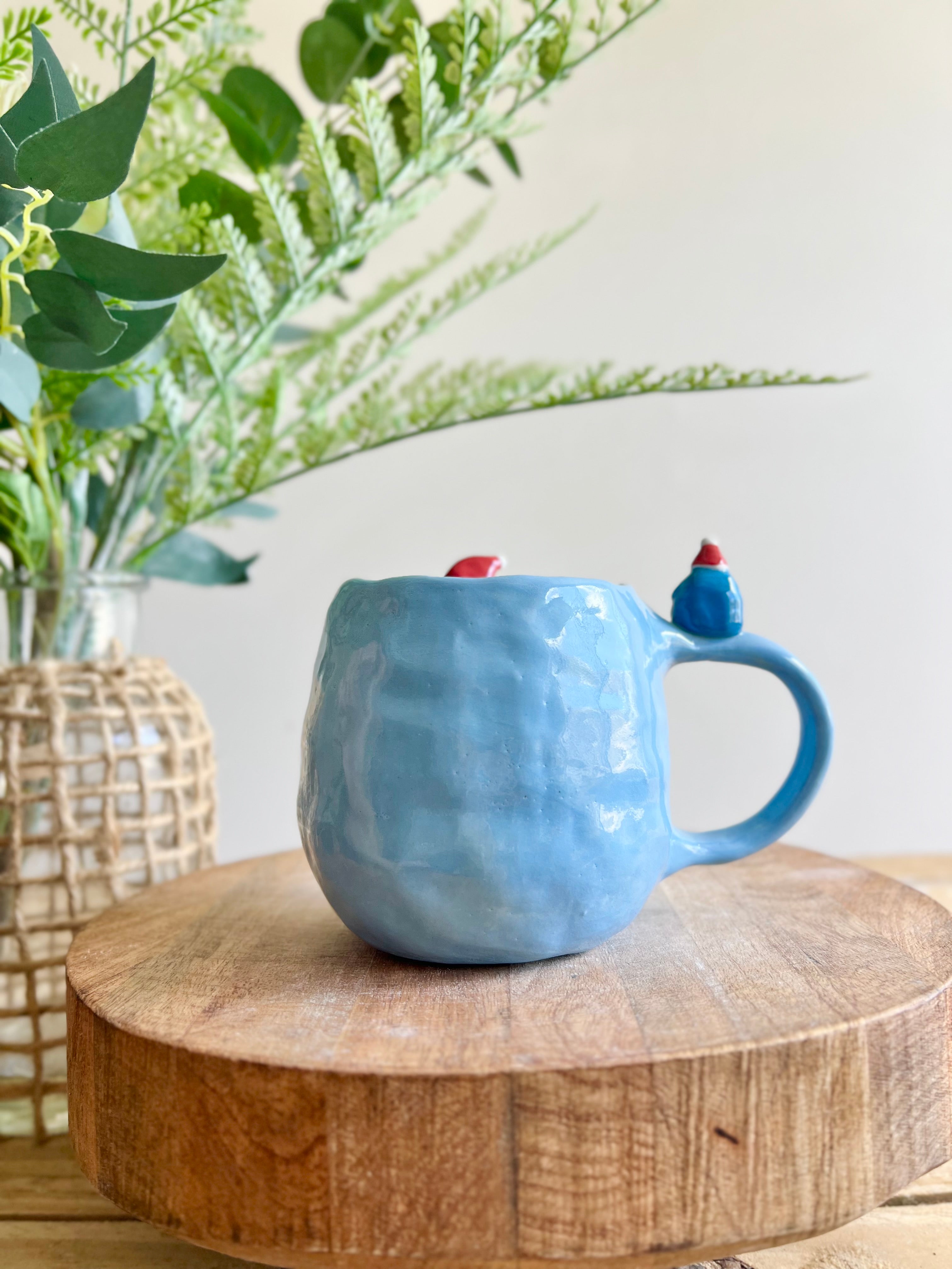 Festive Penguin mug with baby penguin and cat friend