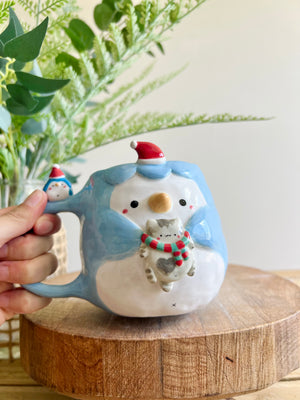 Festive Penguin mug with baby penguin and cat friend