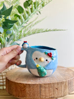 Festive Penguin mug with penguin baby and Christmas tree friend