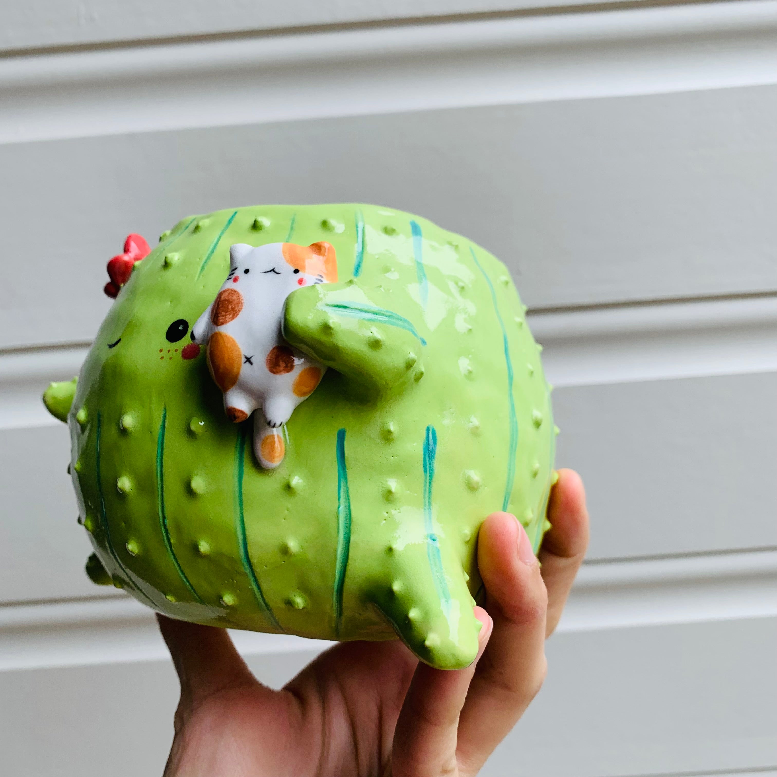 Rotund flowery cactus pot with cat friend