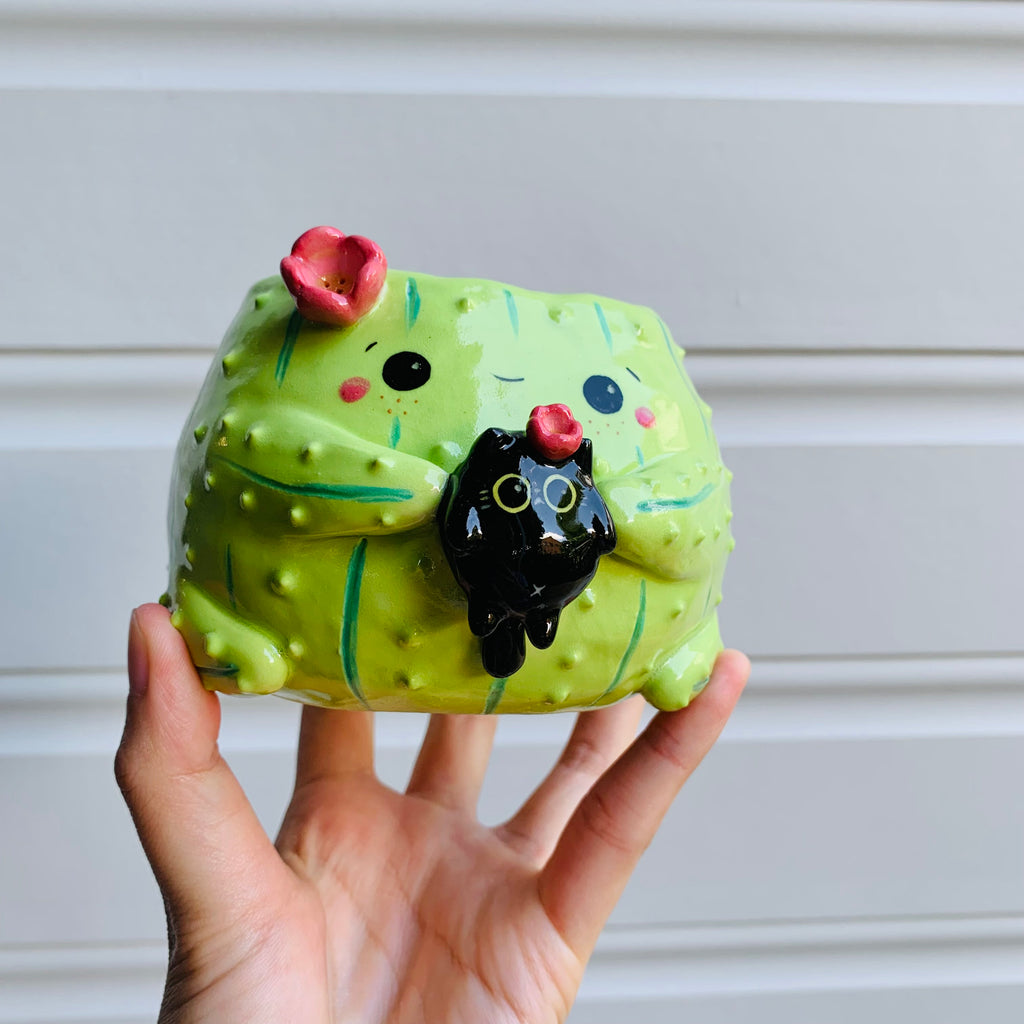 Flowery cactus pot with black cat friend