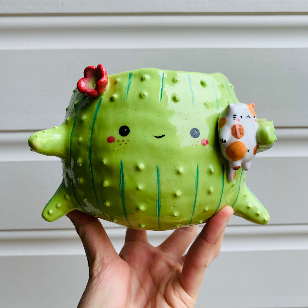 Rotund flowery cactus pot with cat friend