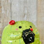 Flowery cactus pot with black cat friend