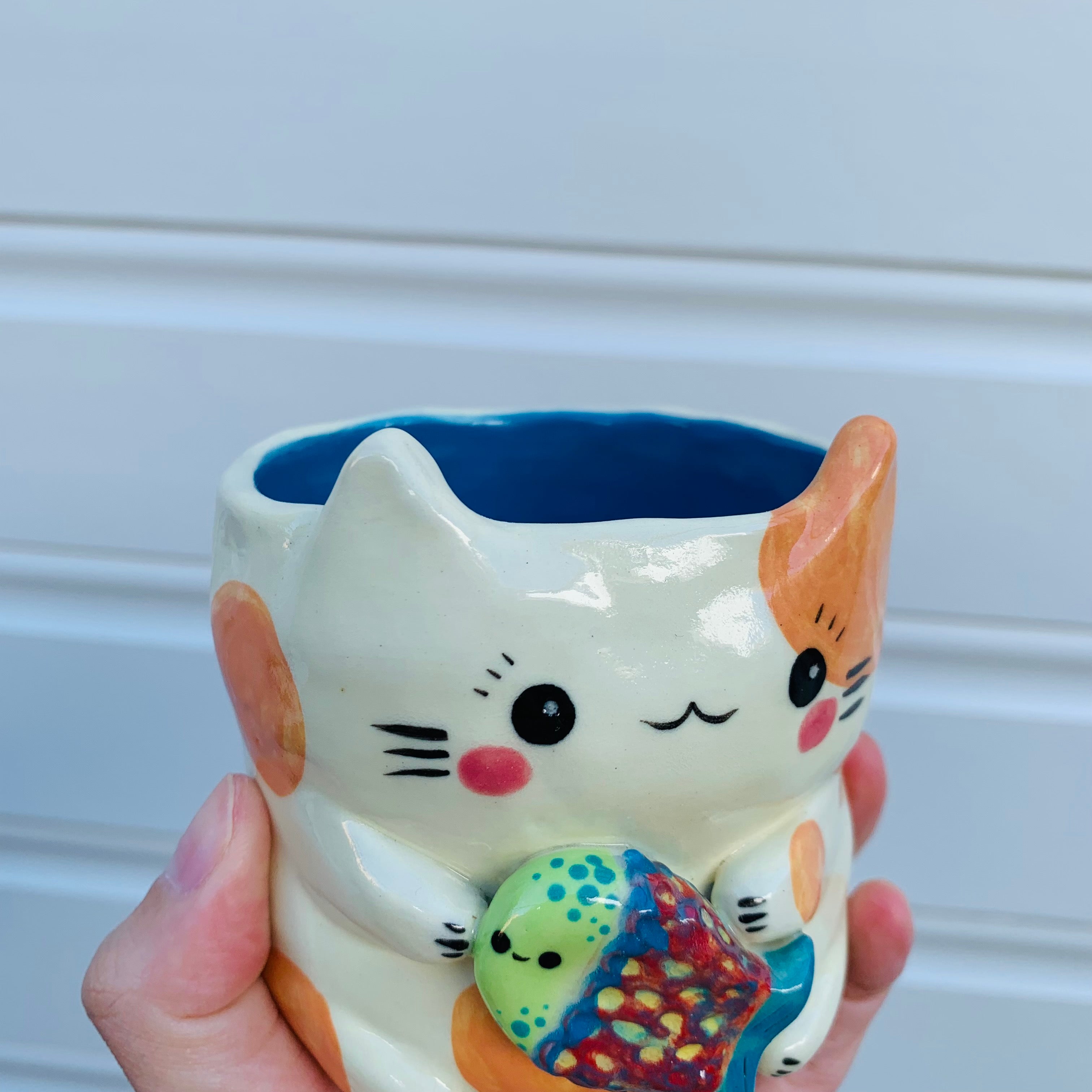 Small spotty cat with fish friend planter