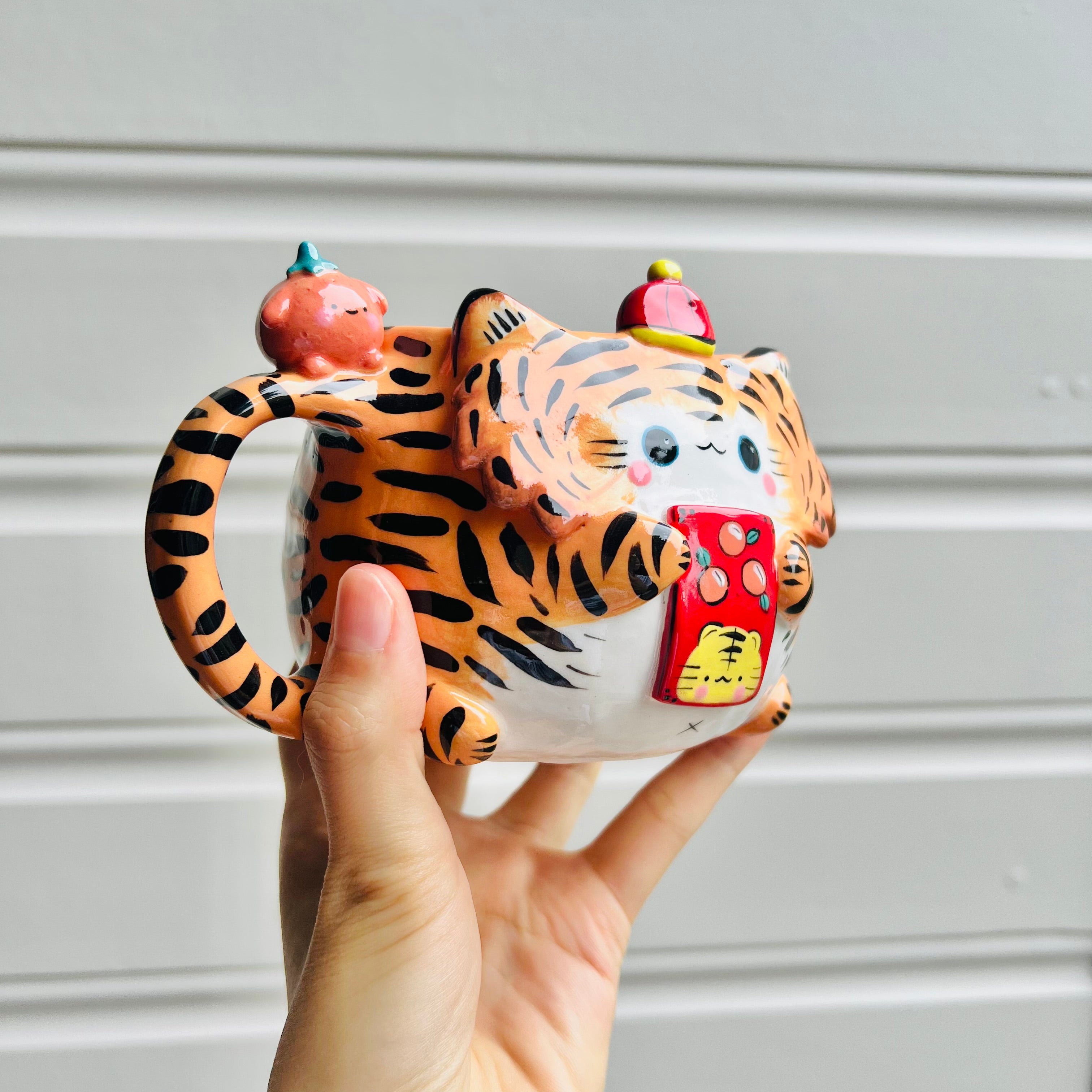 Hat wearing tiger and mandarin friend mug with red packet