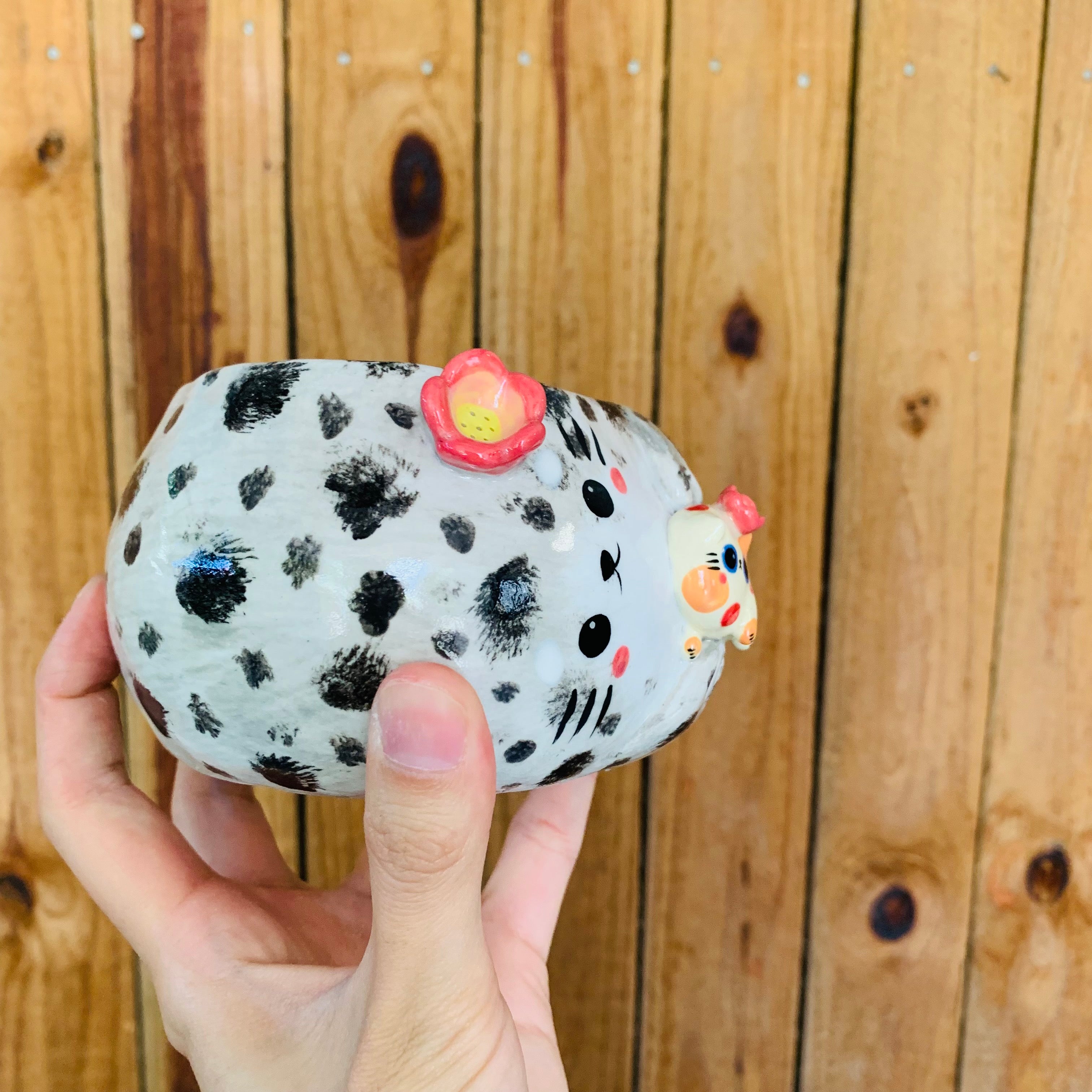 Chubby spotted seal with spotty cat friends pot