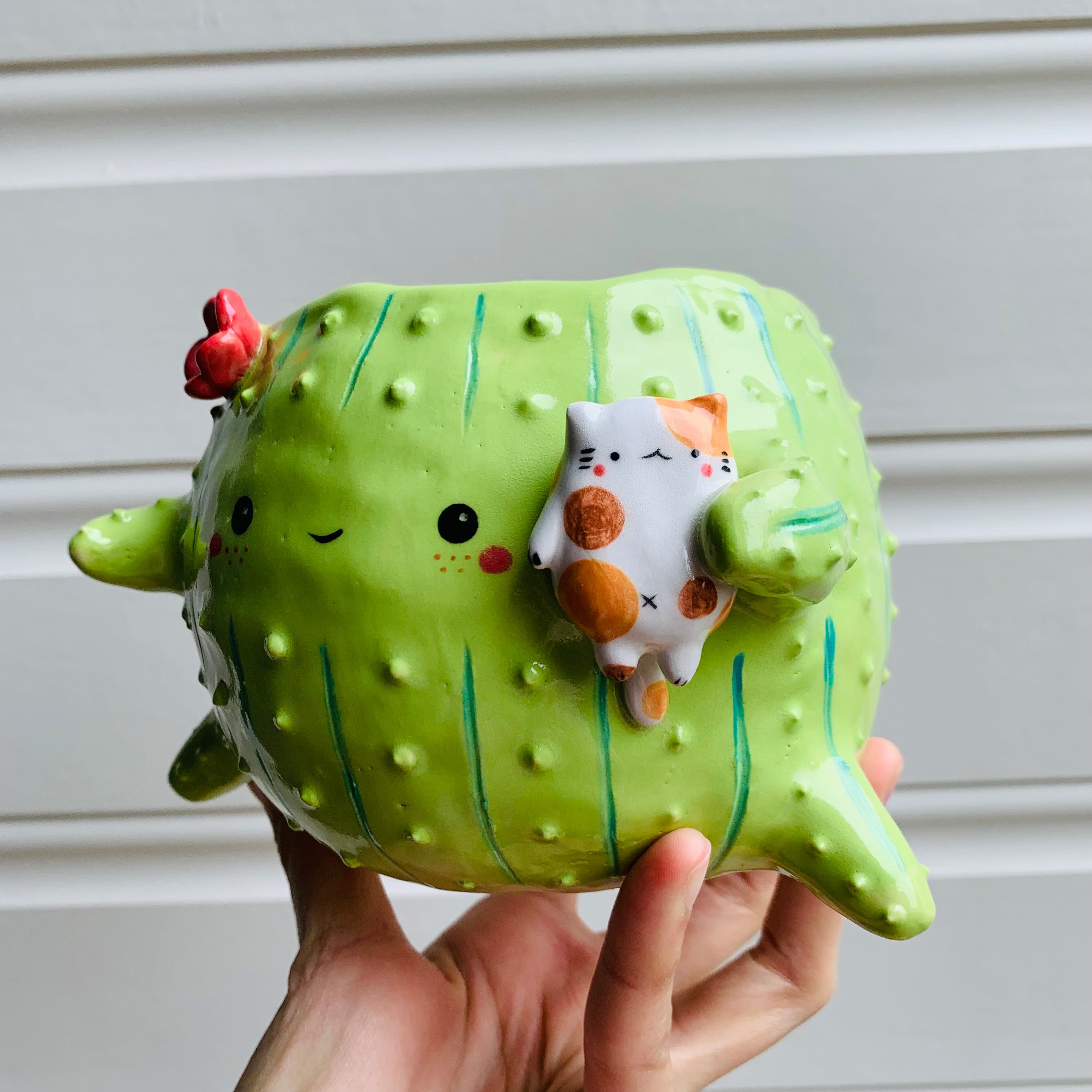 Rotund flowery cactus pot with cat friend