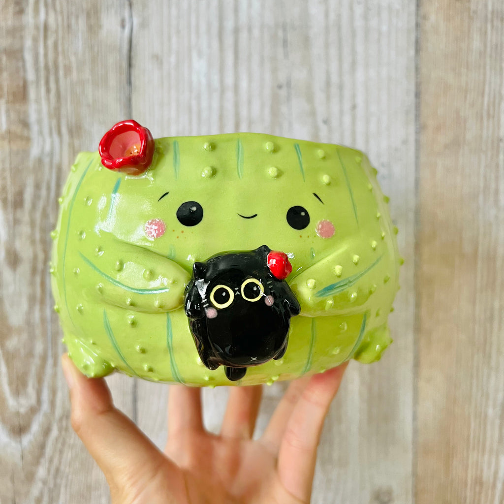 Flowery cactus pot with black cat friend