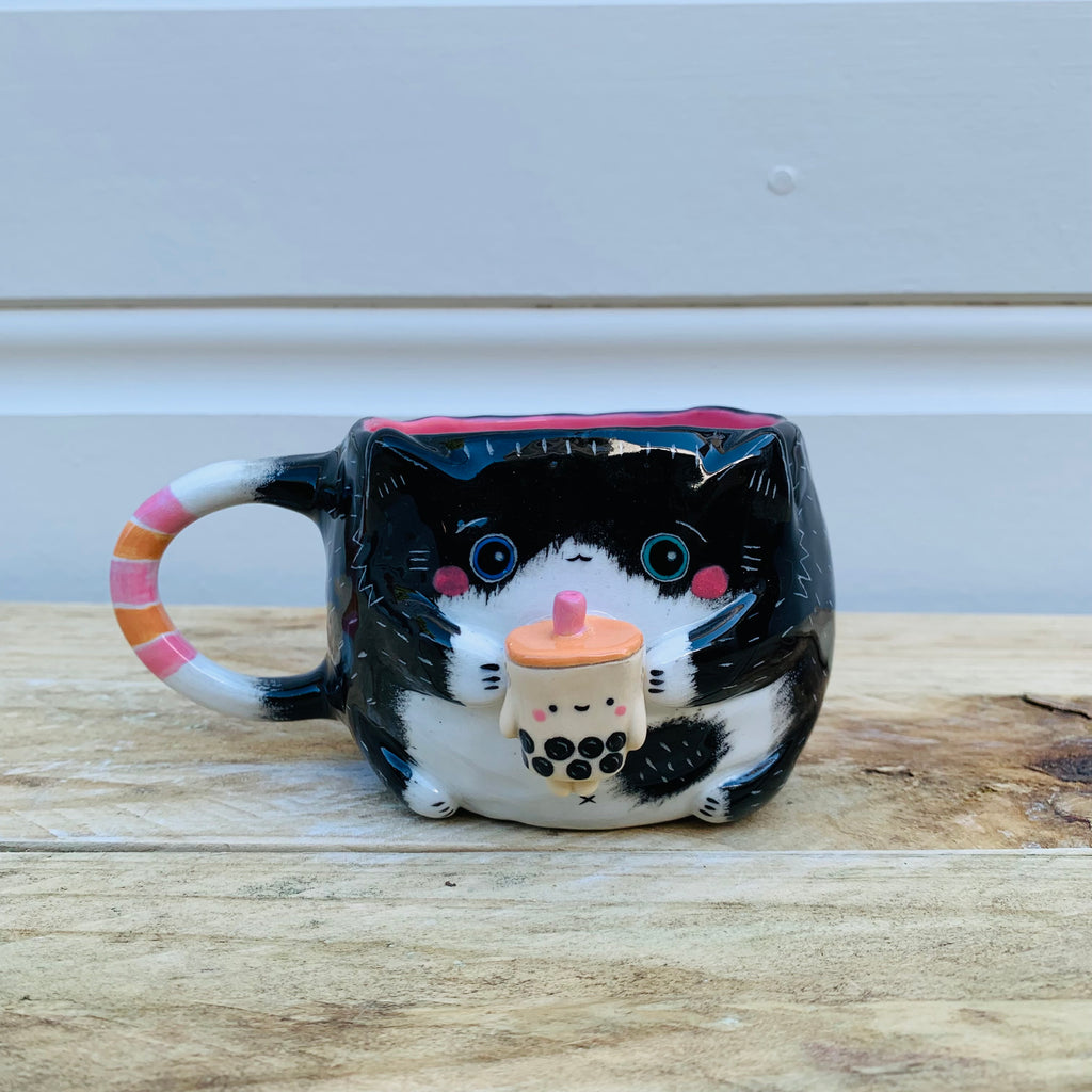 Black and white cat with bubble tea mug