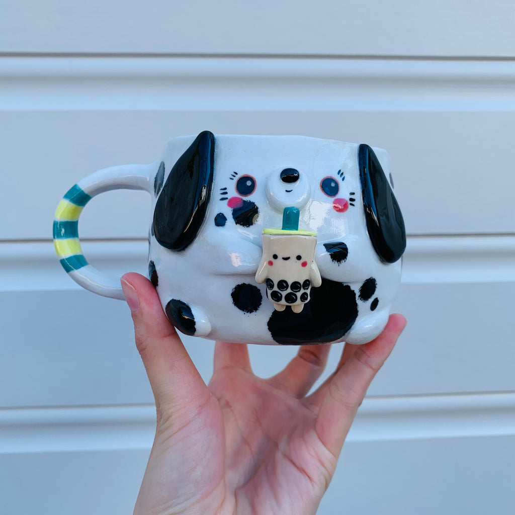 Black and white spotty doggo with bubble tea mug