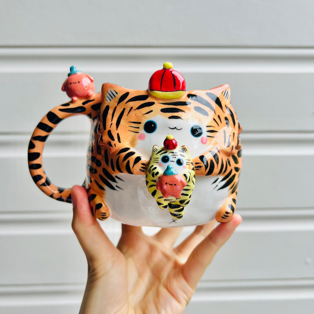 Hat wearing tiger with mandarin friend mug with baby tiger