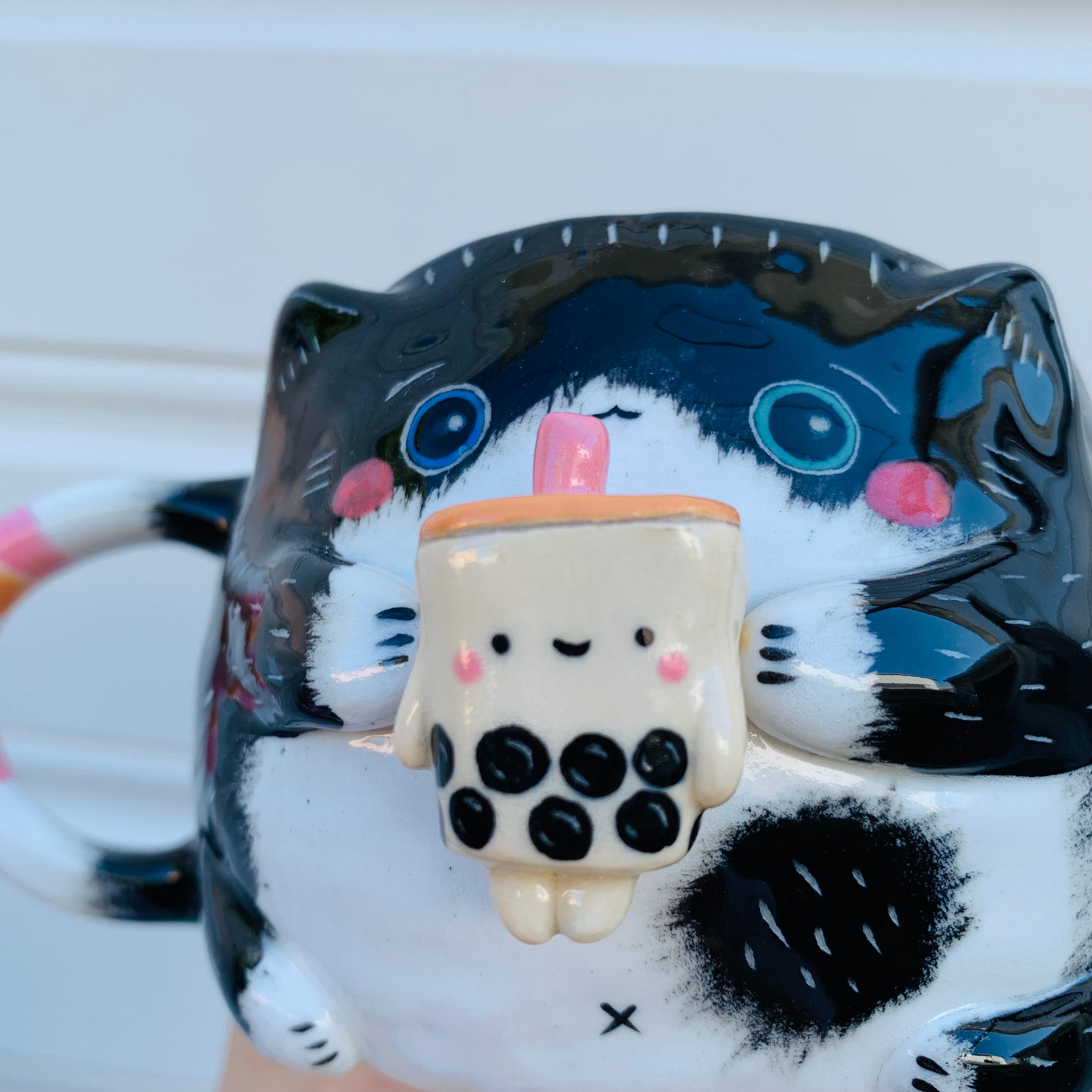 Black and white cat with bubble tea mug