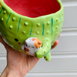 Rotund flowery cactus pot with cat friend