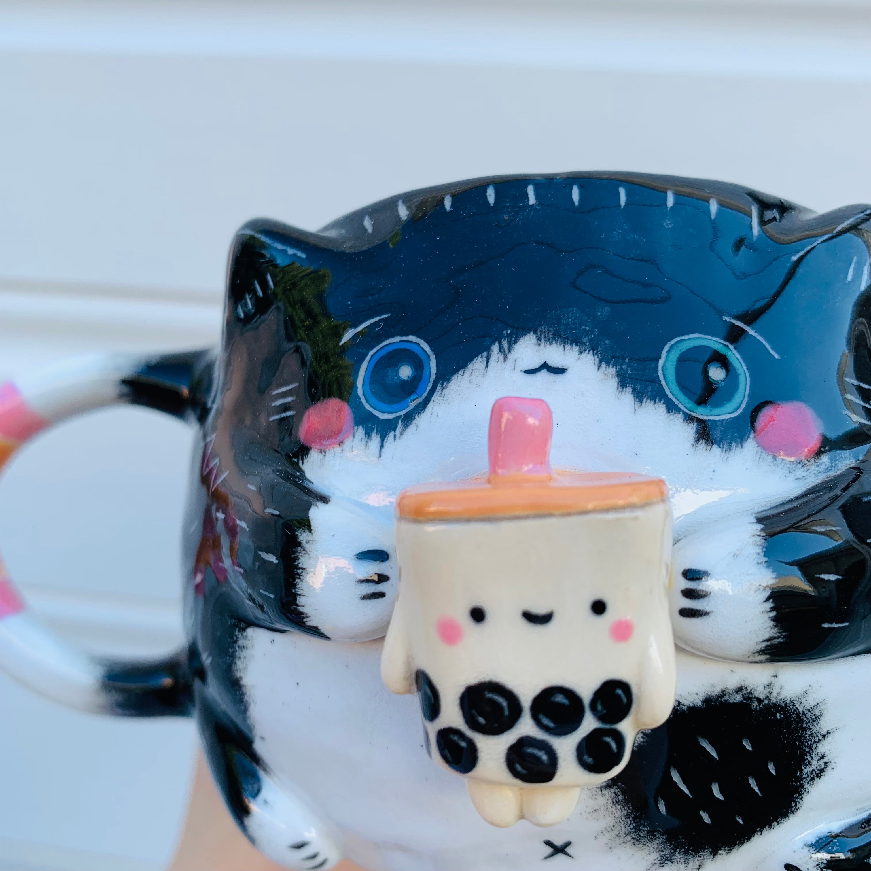 Black and white cat with bubble tea mug