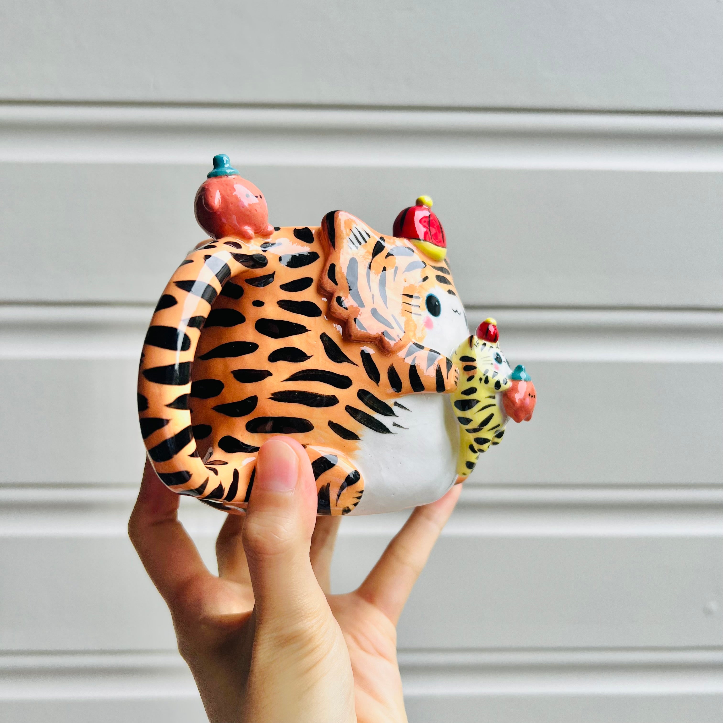 Hat wearing tiger with mandarin friend mug with baby tiger